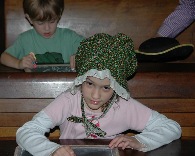 Child with writing tablet at Peter Parley Schoolhouse